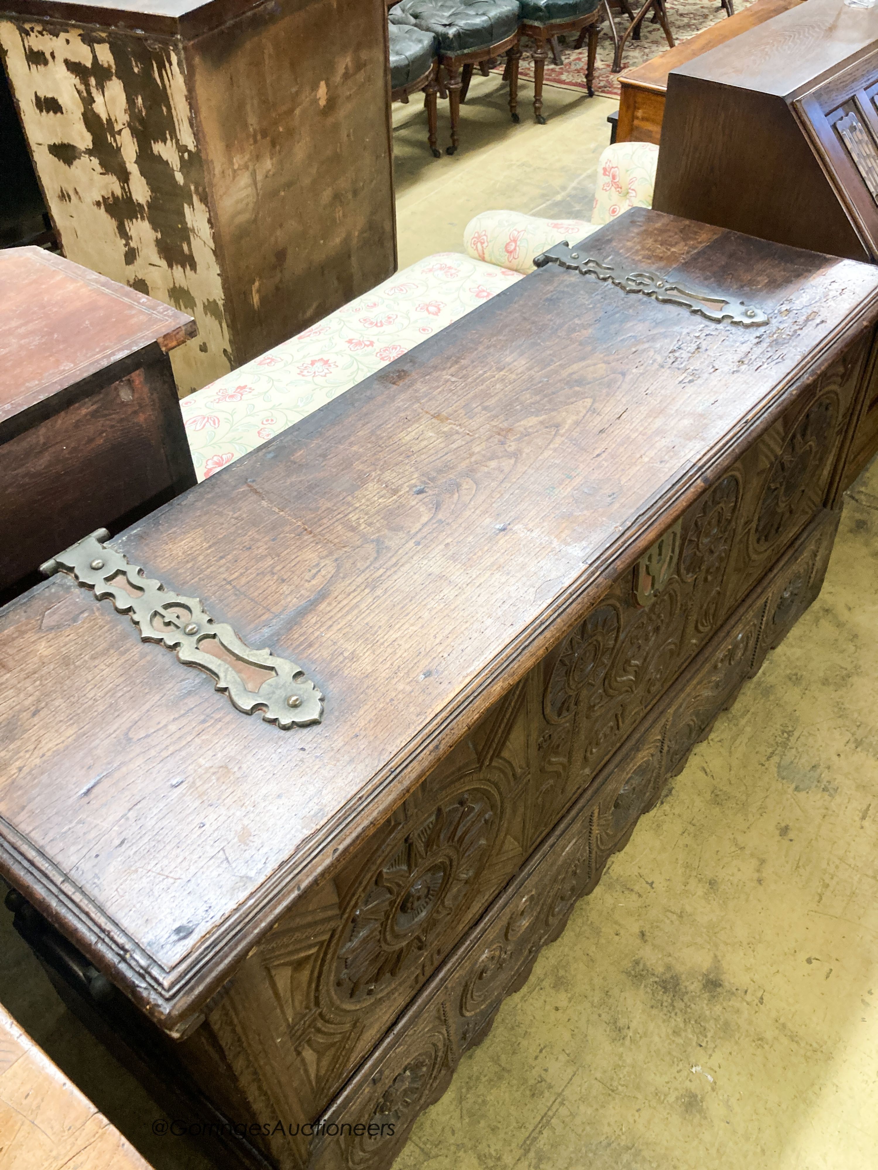 A 17th / 18th century Welsh oak coffer, with carved panelled front and heavy brass strap hinges, W.162cm D.57cm H.78cm